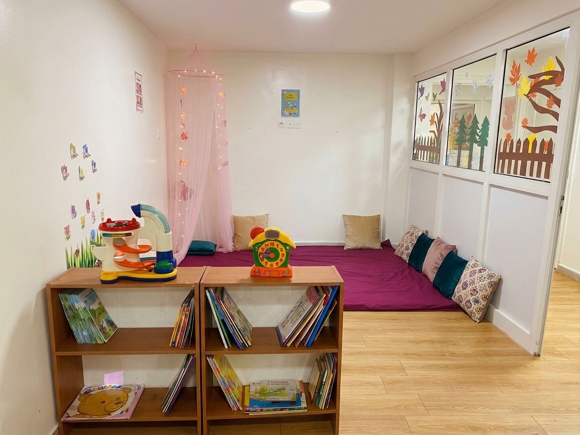 Coin lecture et espace repos de la maternelle, avec bibliothèque et tapis